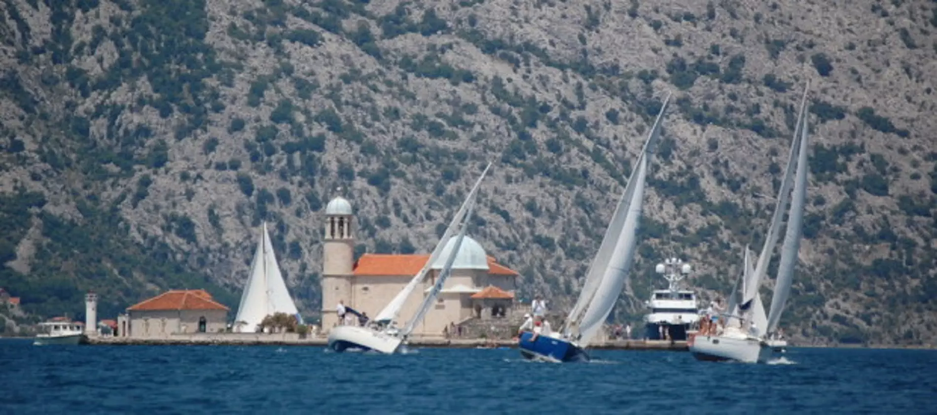 sailing boats racing with an island behind