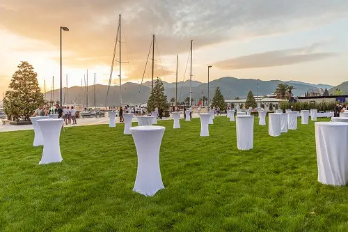 white tables on the green lawn with beautiful sunset